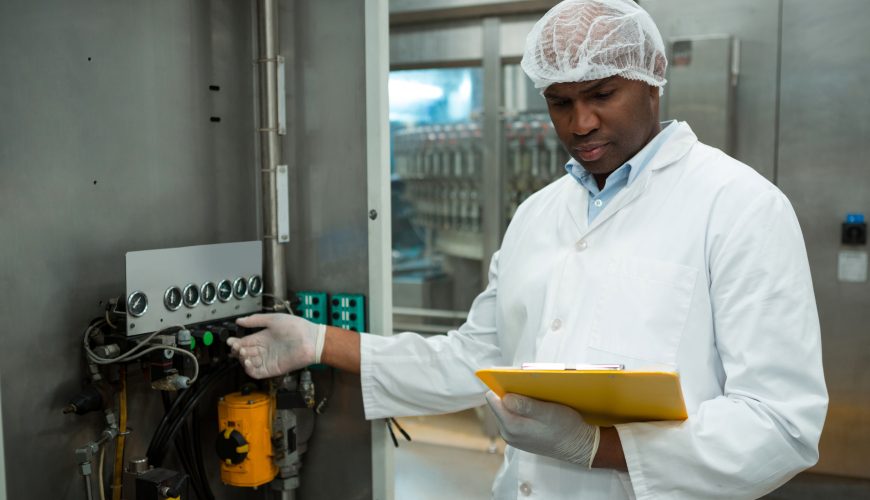 worker-holding-clipboard-while-operating-machine-juice-factory (1)